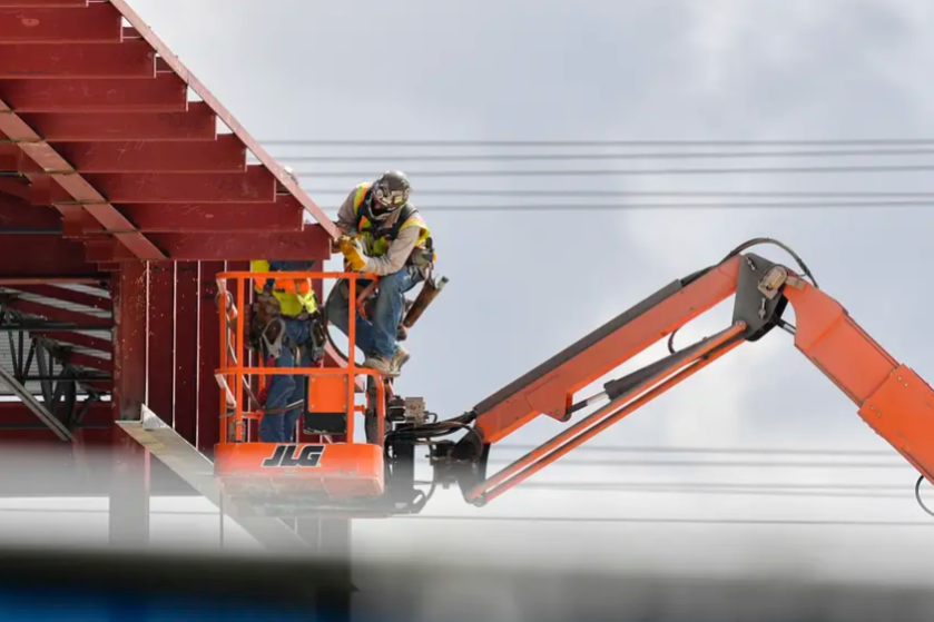 Construction workers work on an office building on the corner or Metric and Parmer in Austin on June 18, 2020.